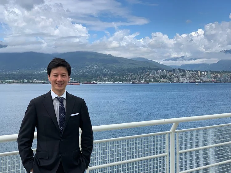 Alan Yeh at Vancouver harbour with the North Shore mountains behind
